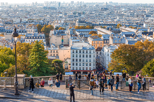 Paris, France - September 29, 2018 : Aerial view over the City of Paris from Montmartre hill in morning with tourists on balcony.