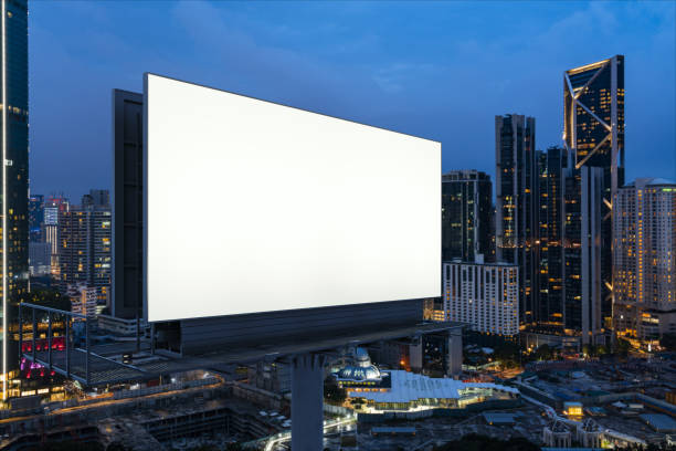 blank white road billboard with kl cityscape background at night time. street advertising poster, mock up, 3d rendering. side view. the concept of marketing communication to promote or sell idea. - billboard bill city advertise imagens e fotografias de stock