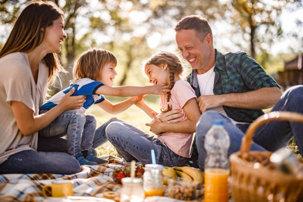 istock Cheerful parents and their small kids having fun during picnic in springtime. 1321450659