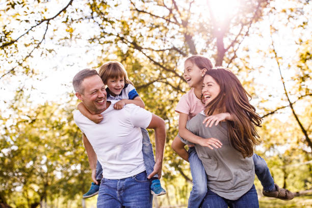 istock Young happy family having fun while piggybacking in spring day. 1321451837