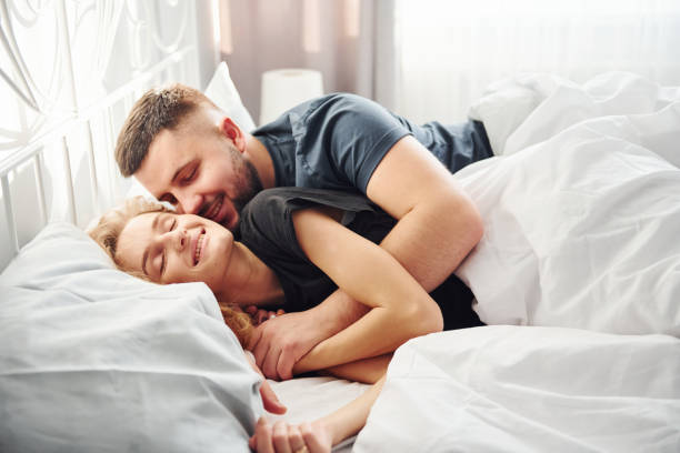 istock Cute young couple lying down on the bed and sleeping together 1321451846