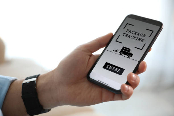 istock Man tracking parcel via smartphone indoors, closeup 1321452963