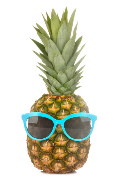 istock Large fresh ripe fruit pineapple in sunglasses on a white isolated background. summer fruit 1321455941