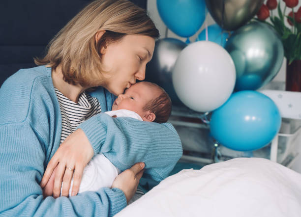 después del parto madre y bebé en casa. la madre sostiene a su recién nacido en las manos. mamá y bebé juntos. - party newborn baby hospital fotografías e imágenes de stock