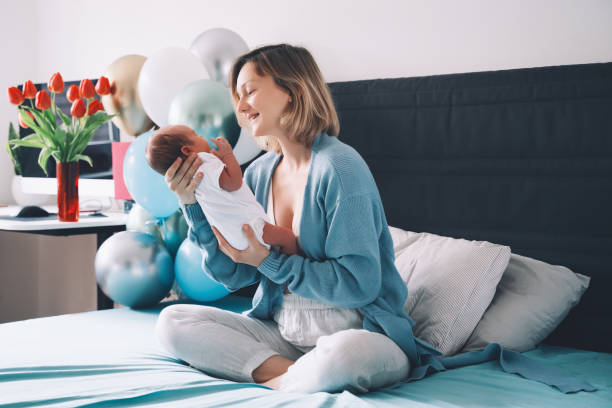 after baby delivery mother and baby at home. mother holds her newborn in hands. mom and baby together. - mother baby new kissing imagens e fotografias de stock