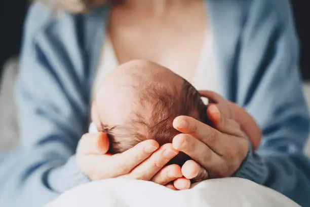 Photo of Newborn in mother's hands. Baby care. Childbirth and motherhood concept. Mother and baby