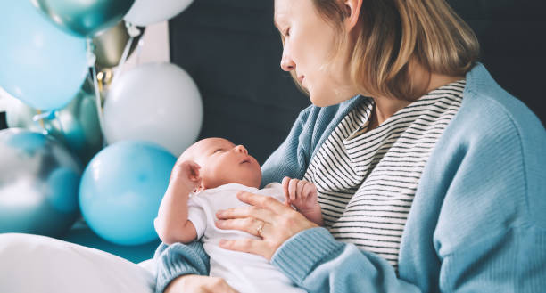 después del parto madre y bebé en casa. la madre sostiene a su recién nacido en las manos. mamá y bebé juntos. - party newborn baby hospital fotografías e imágenes de stock