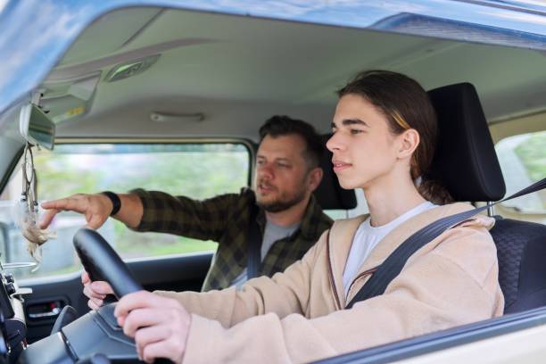 Father teaching his teenage son to drive Father teaching his teenage son to drive. Family, relationship middle aged parent teenager, friendship of father and son teenager boy driving stock pictures, royalty-free photos & images