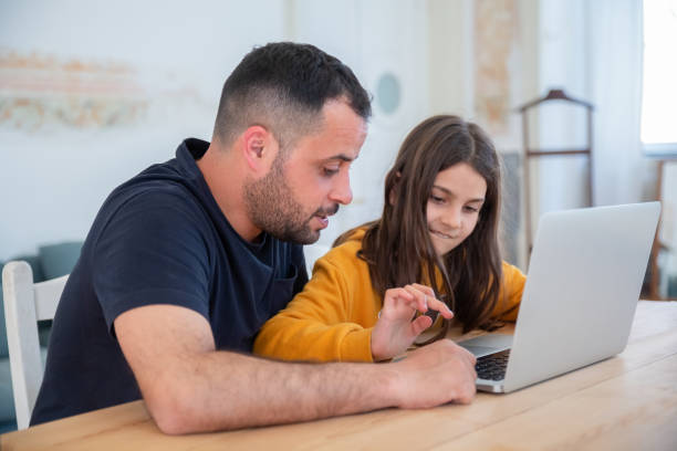 istock Bearded dad teaching daughter to type on keyboard 1321460705