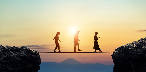 Group of businessperson walking on a tightrope. Risk management.