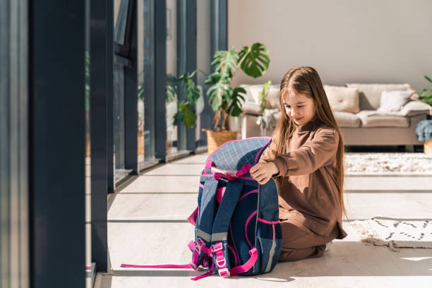 istock Little girl prepares school backpack 1321463304