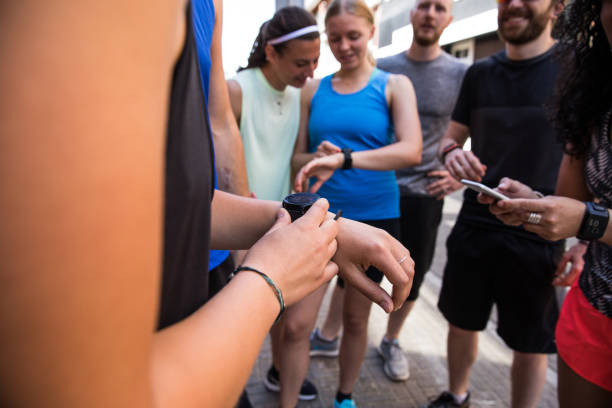 group of runners training in the city streets - checking the time imagens e fotografias de stock