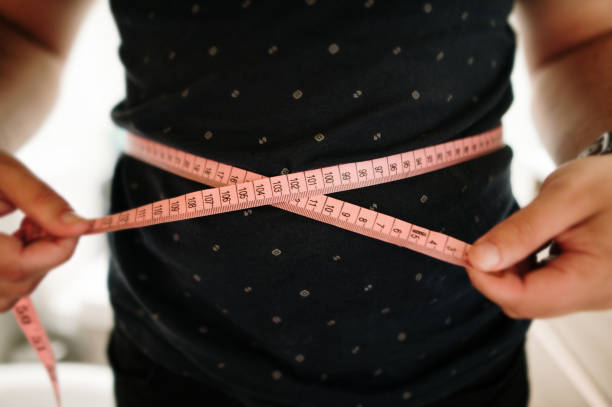 istock Person measuring their belly diameter 1321464898