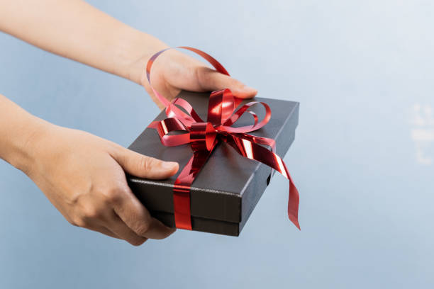 istock Woman hand holding gift box 1321467655