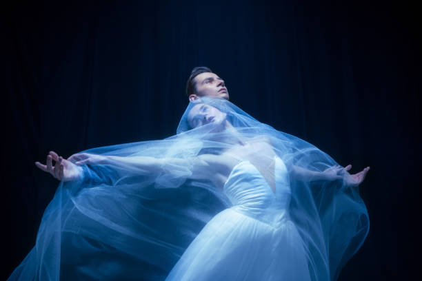 jovem em vestido de noiva e homem, dois bailarinos em performance de arte dançando isolado sobre fundo escuro. - bird fashion color image women - fotografias e filmes do acervo