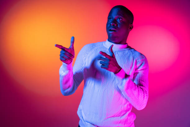 istock One young happy African handsome man isolated over gradient pink yellow neon background. 1321470549