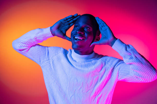 istock One young happy African handsome man isolated over gradient pink yellow neon background. 1321470571