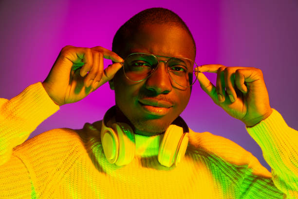 istock Portrait of young African handsome man posing isolated over studio background in gradient neon light 1321470612