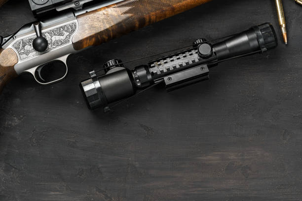istock The optical sight and shotgun on wooden backgorund 1321472392