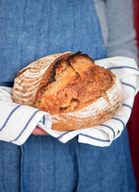 istock Female hands holding freshly baked homemade bread 1321473342