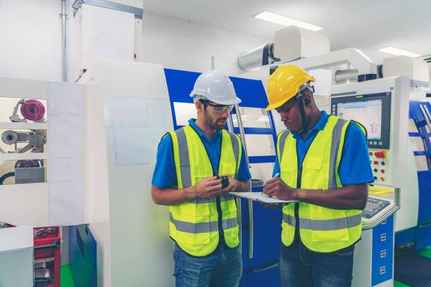 istock Assistant using control machine operating control CNC machinery at factory Industrial. 1321473362