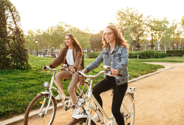 istock Two young beautiful women friends outdoors with bicycles 1321475556
