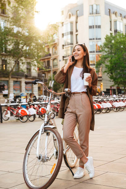 istock Young pretty woman outdoors with bicycle drinking coffee. 1321476765