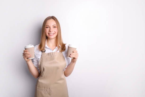 istock Beautiful woman in apron with coffee on white background 1321478237