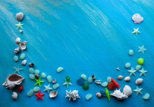 istock Seashells summer background. Many different seashells, starfish on a background of blue paint strokes. Place for text with border at the bottom edge 1321479426