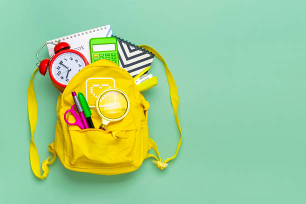 istock Frame from of office supplies Paper clips, scissors, pens, felt-tip pens, sharpener, backpack, calculator, stapler isolated on green background Flat lay Top view Back to school, education concept 1321480440