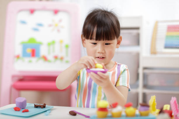 istock Cute Girl Playing With Clay At Home 1321483000