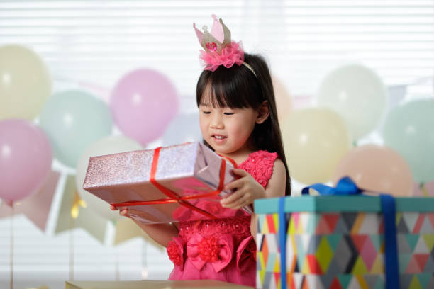 istock Girl Holding Gift During Birthday At Home 1321483532