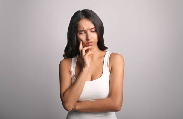 istock Young woman has toothache on  grey background 1321484069