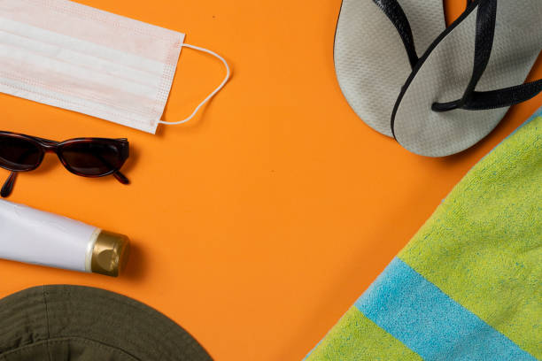 istock sunglasses, facemask and beach objects on orange summer beach background 1321485063