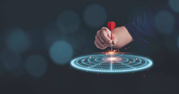 istock Businessman throwing red arrow dart to virtual target dart board. Setup objectives and target for business investment concept. 1321485328