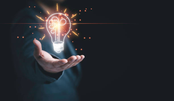 istock Businessman holding half of virtual lightbulb and brain on blue bokeh background , Smart thinking idea and inspiration innovation concept. 1321485666