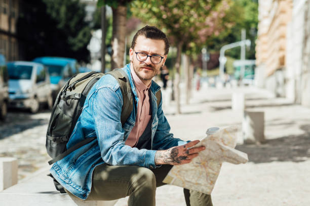 istock Portrait of a young tourist taking a rest and looking for a direction into the map 1321486708