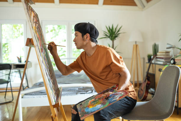 un japonais passe le week-end matin à peindre dans sa chambre à la maison - artiste peintre photos et images de collection