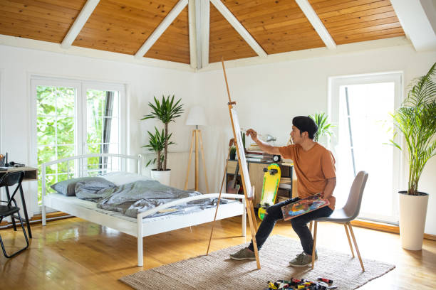 istock Talented painter expressing his creativity on canvas in bedroom at home 1321486873