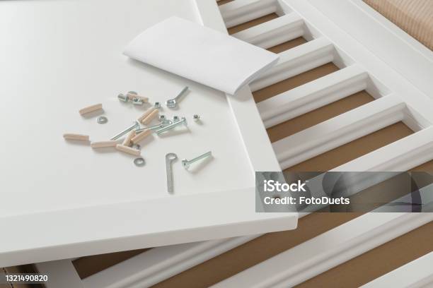 White Wooden Planks Screws And Instruction Book For Crib In Cardboard Box Preparation For Future Baby Assembling New Furniture Closeup Stock Photo - Download Image Now