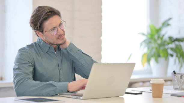 istock Middle Aged Man with Laptop having Neck Pain 1321490872