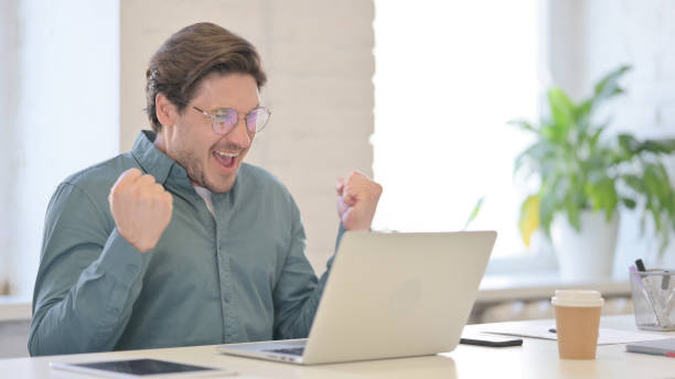 istock Successful Middle Aged Man Celebrating on Laptop in Office 1321490938