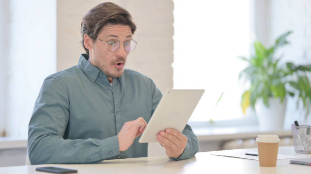 istock Middle Aged Man Reacting to Loss on Tablet 1321491032