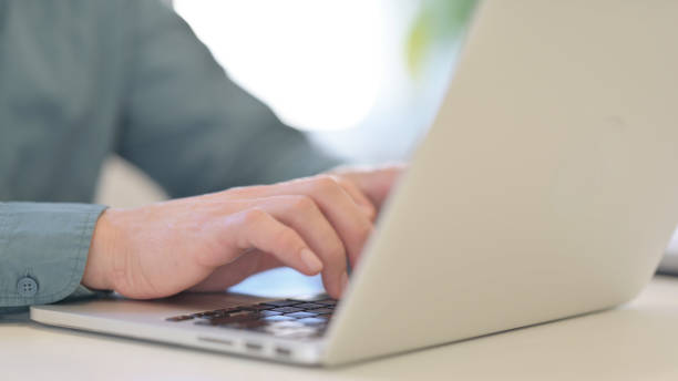 istock Hands of Middle Aged Man Typing on Laptop 1321491069