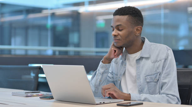 istock African Man with Laptop Falling Asleep in Office 1321492213