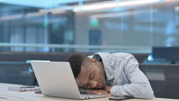 istock African Man with Laptop Taking Nap in Office 1321492224