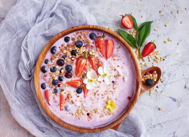 istock yogurt, granola, strawberry, blueberry on a concrete background 1321496944