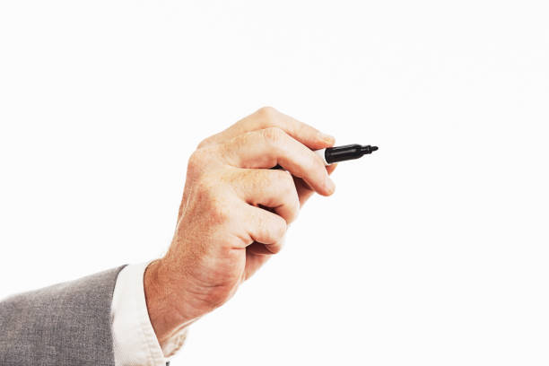 Hand of businessman wearing suit holds a felt-tip pen poised to write Man's hand holding a permanent marker or whiteboard marker. permanent marker photos stock pictures, royalty-free photos & images