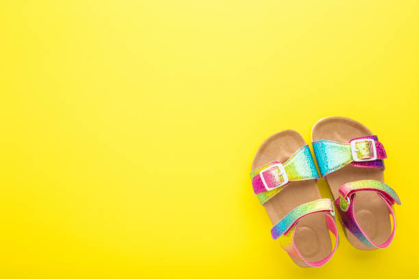 Kids leather sandals on leg isolated on a white background, copy space template.