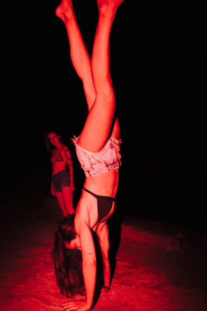 gruppe junger frauen, die sich nachts bei einer seeparty mit roter ampel amüsieren - acrobatic activity flash stock-fotos und bilder